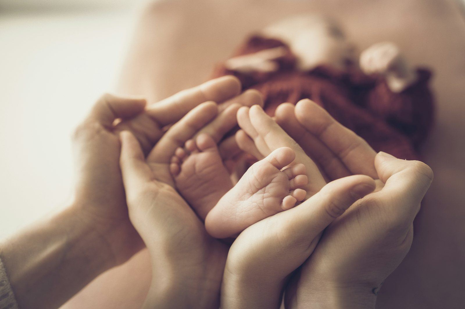 Piedini di un neonato nelle mani dei genitori per un ricordo della festa del papà