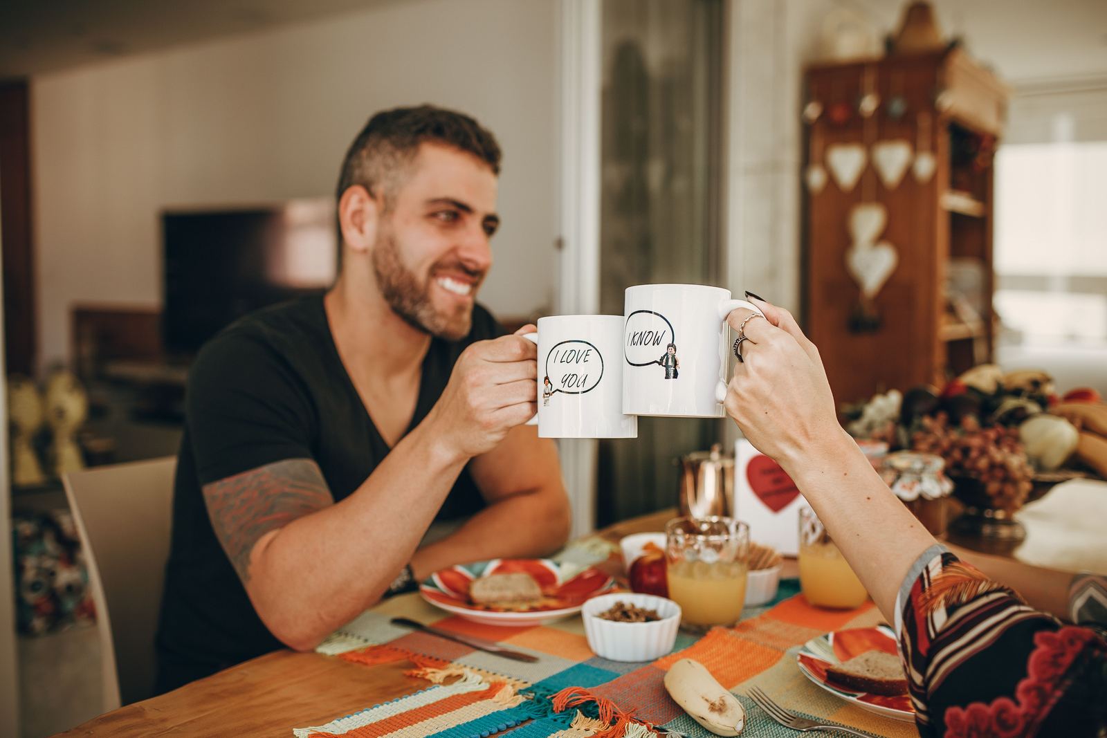 Coppia che brinda con tazze personalizzate a colazione
