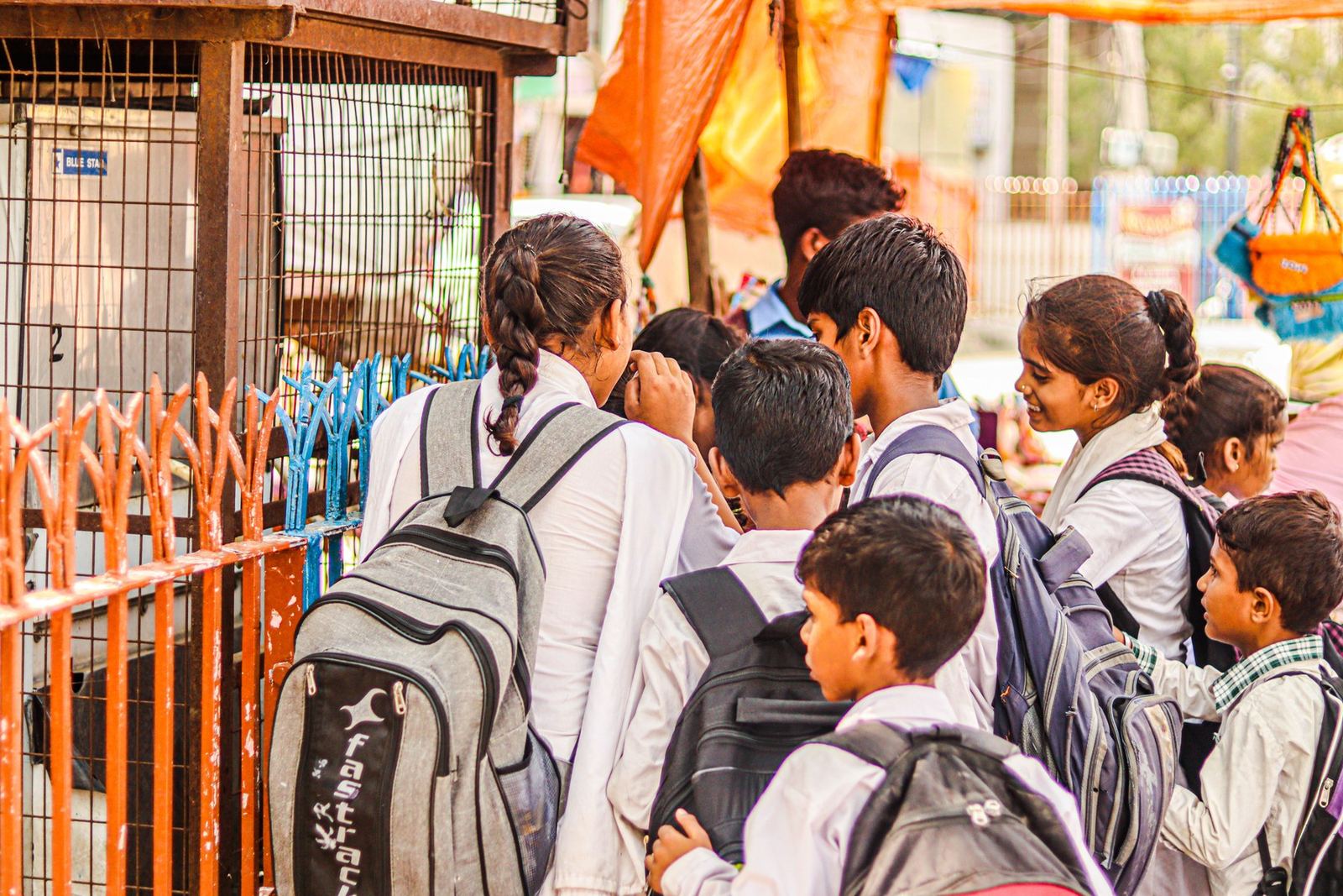 Group of schoolchildren wearing backpacks and standing together outdoors