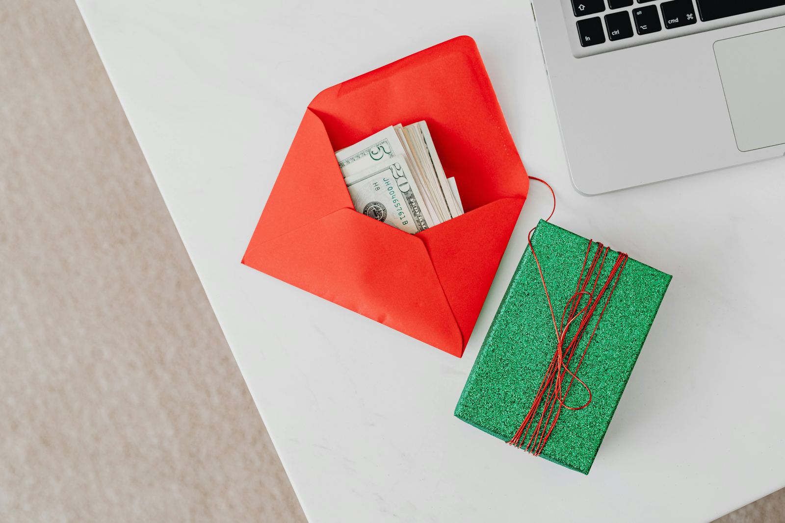 Envelope with money next to a gift.