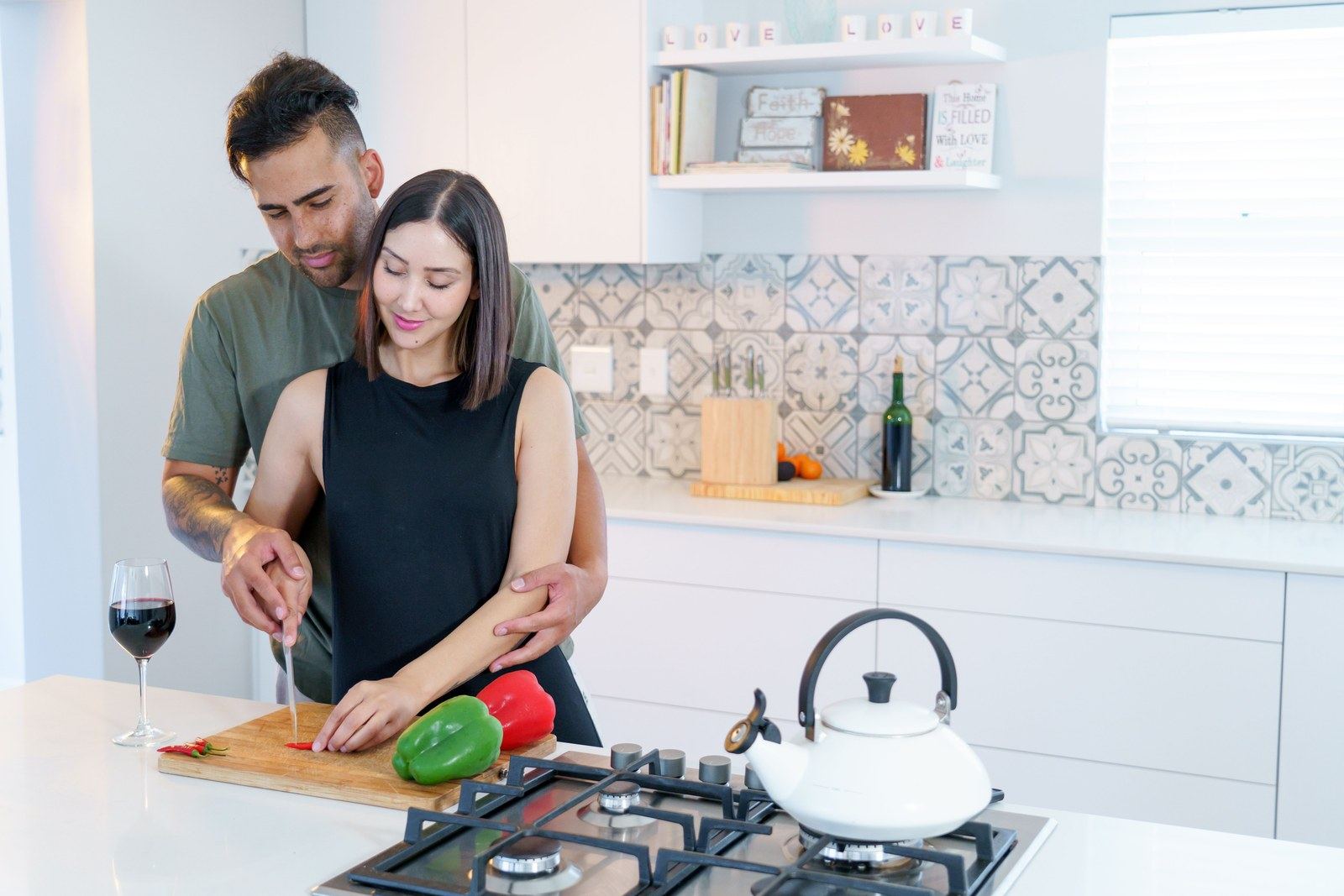 A couple cooking together in a bright modern kitchen