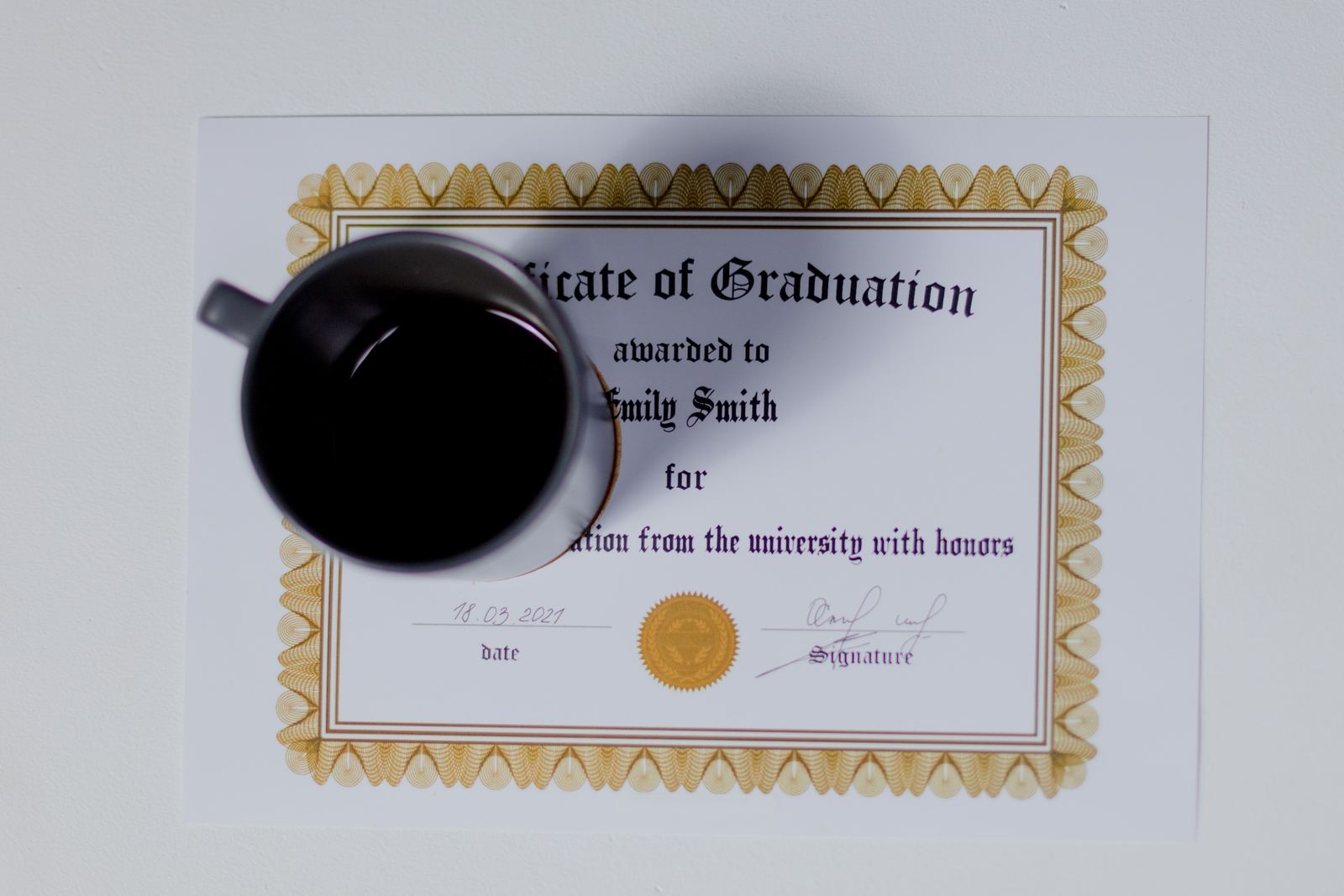 Tasse de café posée sur un certificat de remise de diplôme