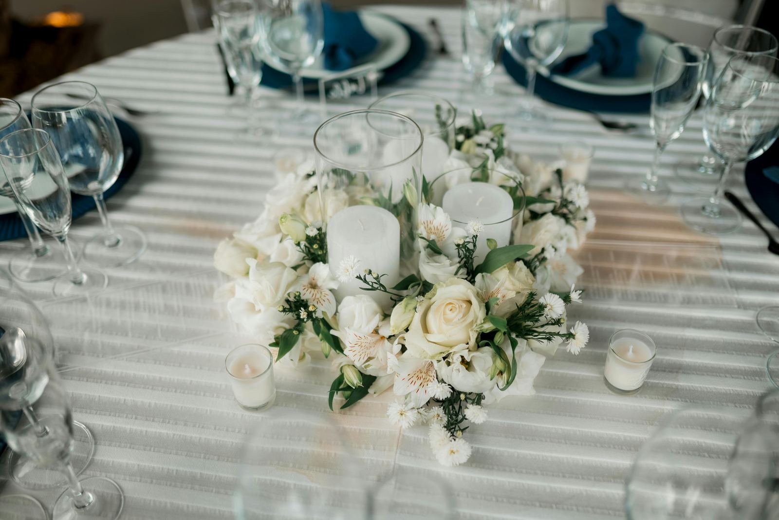 Table centerpiece with white candles and wedding flowers