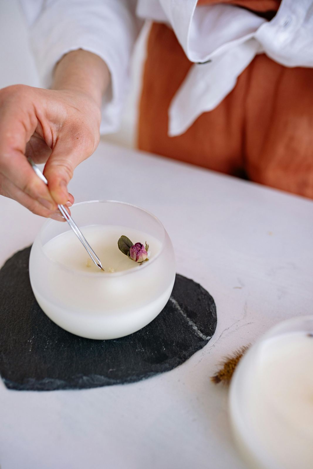 Dried flower placed on a handmade candle during decoration