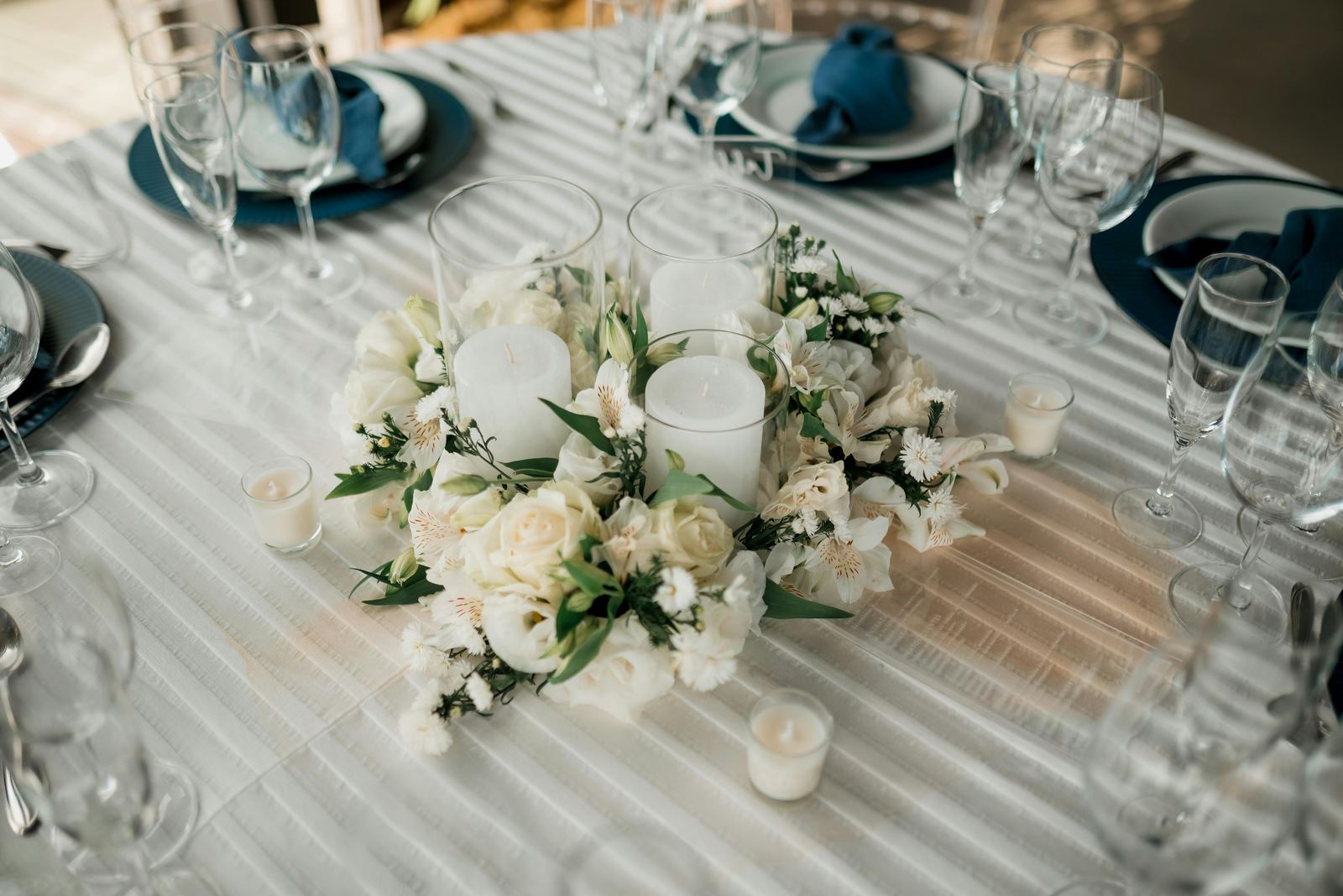 White personalized candle on a wedding table with eucalyptus