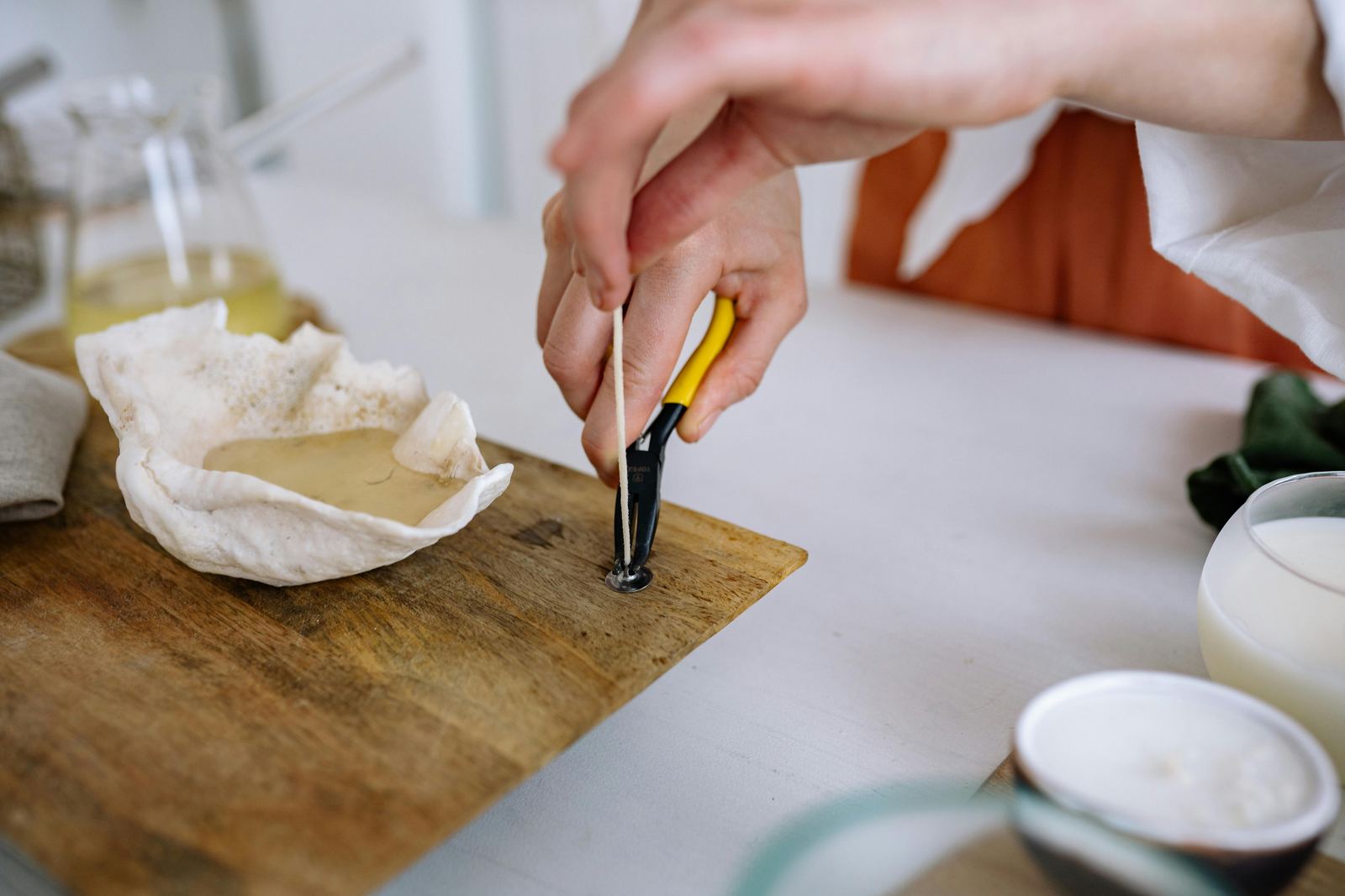 Candle wick centered with pliers during a DIY workshop
